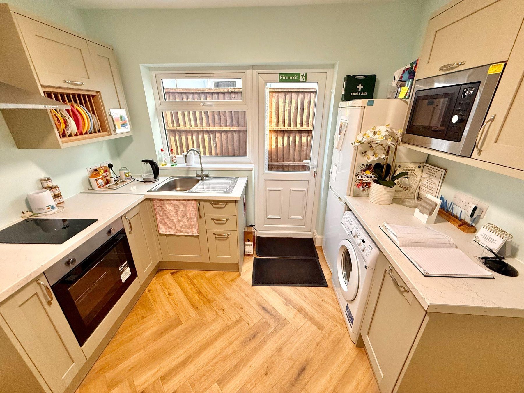 Galley kitchen with washing machine, microwave and rear exit door