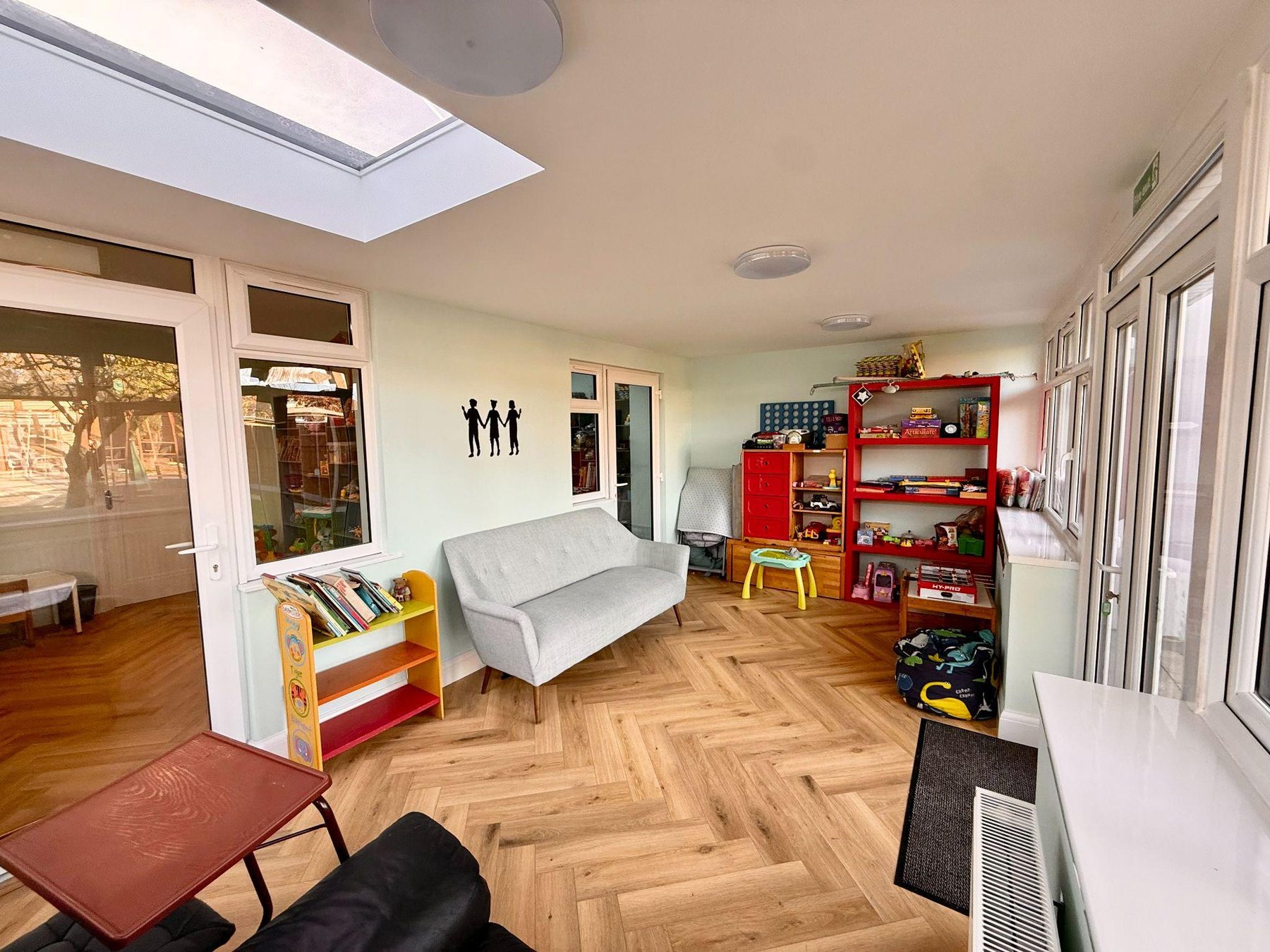 Bright garden room with sofa, book trolley and play kitchen